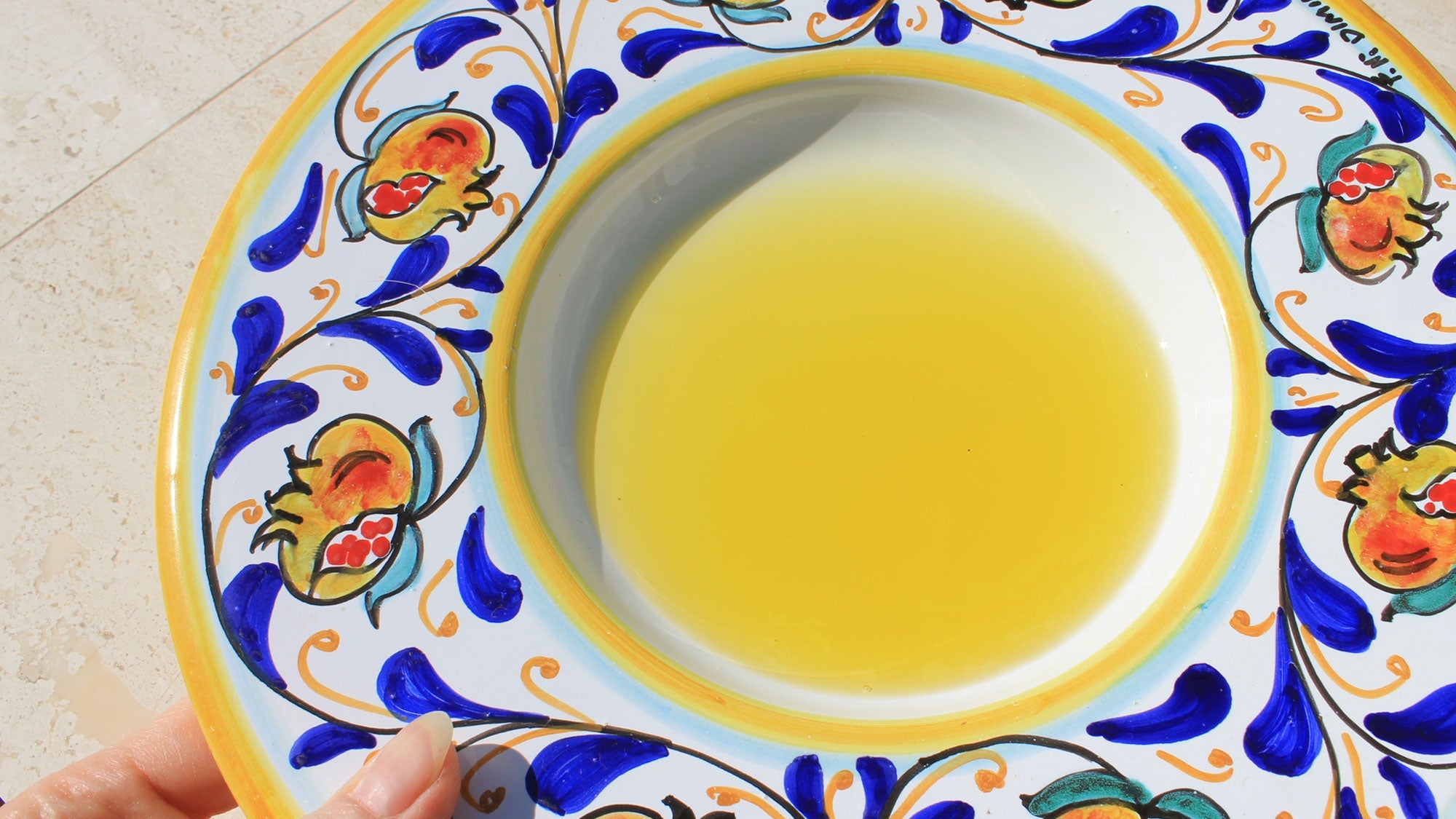 hand-painted ceramic pasta bowl with golden yellow oro sicani extra virgin olive oil in the centre