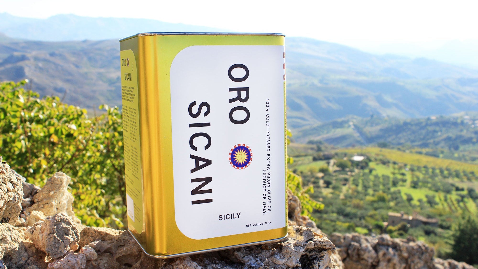 Oro Sicani extra virgin olive oil tin with a scenic background of the sicani mountains of sicily, italy